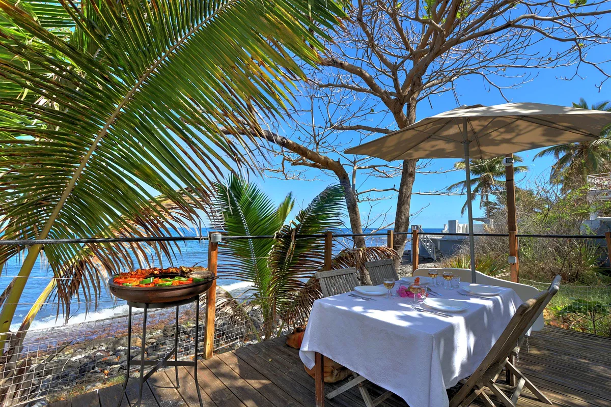 Les tables dressées au bord de la mer, avec le barbecue