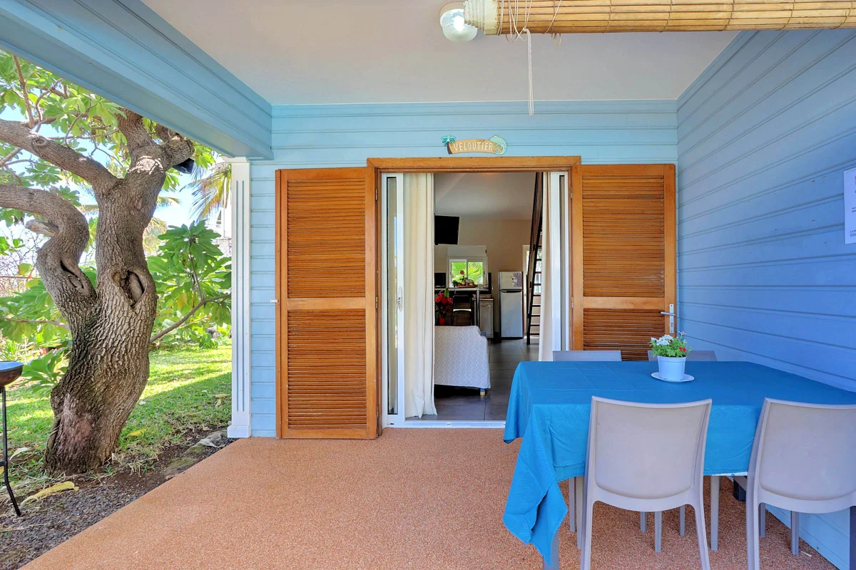 La terrasse d'une villa créole bleue, sa table et ses chaises