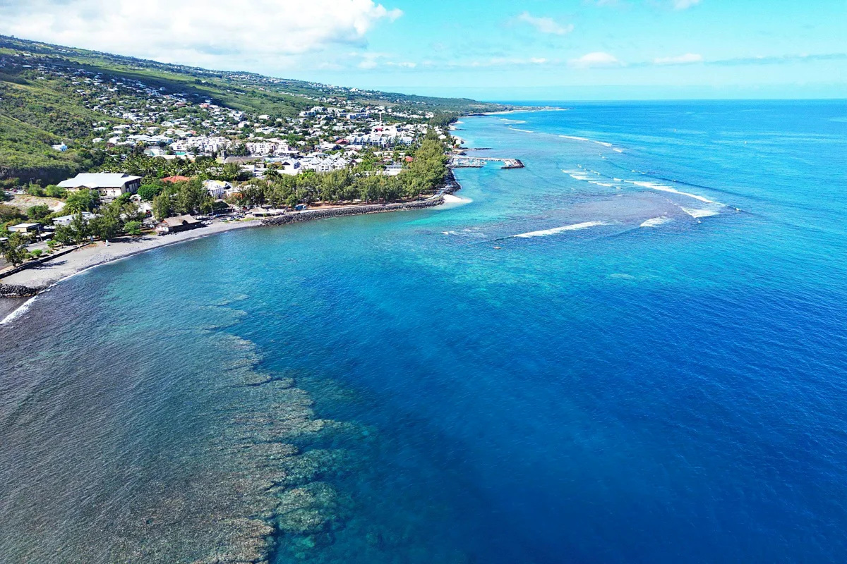 Le lagon et la barrière de corail de Saint-Leu vus du ciel, la ville au fond