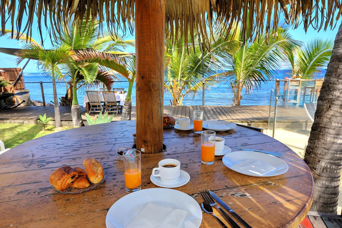 Un petit déjeuner sur la table ronde, sous la paillote, face à la mer