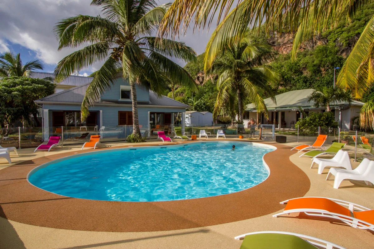 La piscine chauffée, ses transats orange et une villa créole